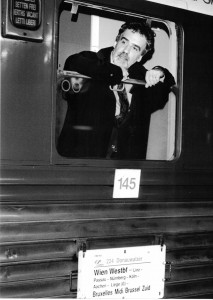 schwarz-weiß-Photographie eines Mannes, der aus einem Zug blickt
